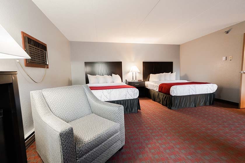 View of seating and two queen beds in hotel room
